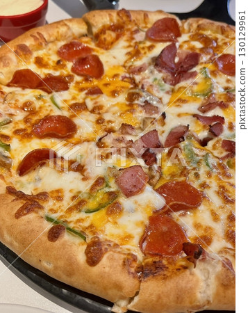 A delicious pizza with a golden crust, melted cheese, and savory toppings. Perfect for food-related designs, menus, or Italian-themed projects, capturing the essence of a classic comfort dish. A delicious pizza with a golden crust, melted cheese, and savory toppings. Perfect for food-related designs, menus, or Italian-themed projects, capturing the essence of a classic comfort dish. 130129961