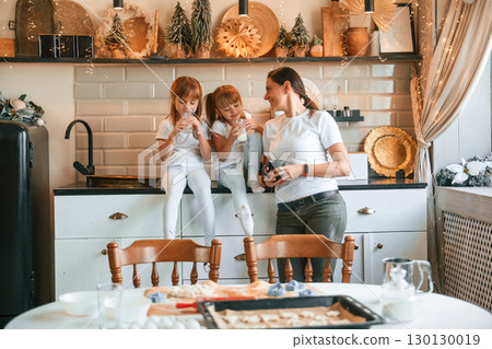 Mother and two little girls are chilling on the holiday kitchen 130130019