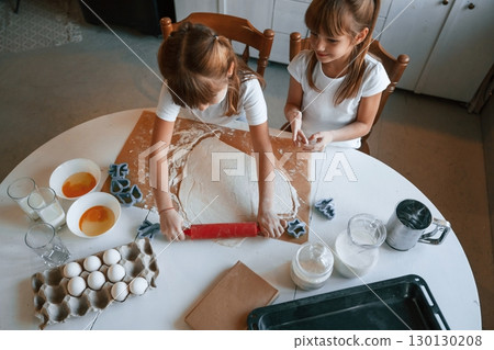 Dough on the table. Two little girls are preparing food on the kitchen 130130208