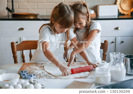 Dough on the table. Two little girls are preparing food on the kitchen Dough on the table. Two little girls are preparing food on the kitchen 130130209