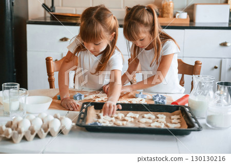 Raw sweet cookies. Two little girls are preparing food on the kitchen with garlands 130130216