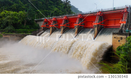 Large red dam gates releasing strong water flow in rainy season 130130348