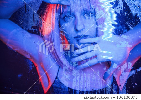 Futuristic style. Stylish woman with white hair is behind wet transparent plastic sheet 130130375