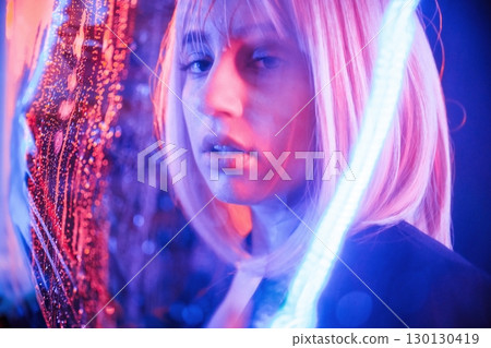 Posing, calm facial expression. Stylish woman with white hair is behind wet transparent plastic sheet 130130419