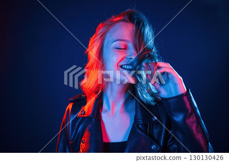 Positive facial expression. Cool young woman portrait in neon colors 130130426