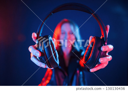 With headphones. Cool young woman portrait in neon colors 130130436