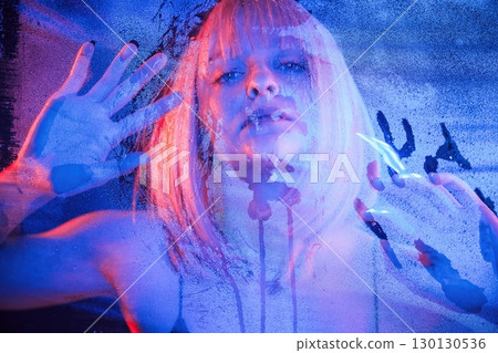 Cold blue color. With hands on the wet transparent plastic sheet. Stylish woman with white hair Cold blue color. With hands on the wet transparent plastic sheet. Stylish woman with white hair 130130536