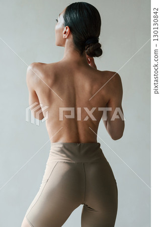 Back view of sporty woman that is without bra indoors Back view of sporty woman that is without bra indoors 130130842