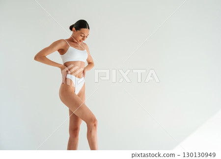 Results of diet and healthy eating. Woman in white underwear with slim body type against white background 130130949