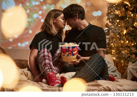 Holding popcorn. Couple celebrating New Year together 130131213