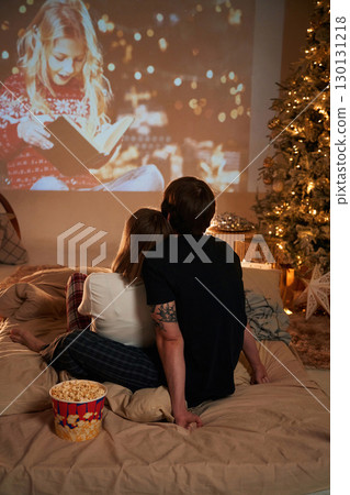 Beautiful young couple indoors, celebrating new year against projector Beautiful young couple indoors, celebrating new year against projector 130131218