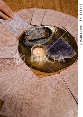 Tarot card reading session with crystals and candles on a wooden table in a cozy room during the evening 130131371