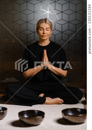 Meditation practice in a serene setting with tibetan singing bowls and a calm atmosphere during evening hours 130131394