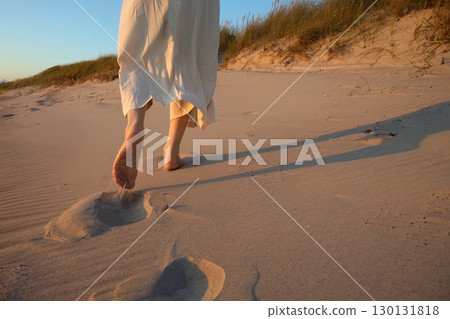 Beach Walk at Sunset. Silhouette of feet on a sandy beach at sunse 130131818