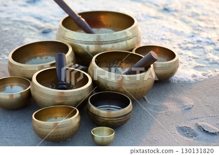 Singing Bowls on Sand at sunrise. 130131820