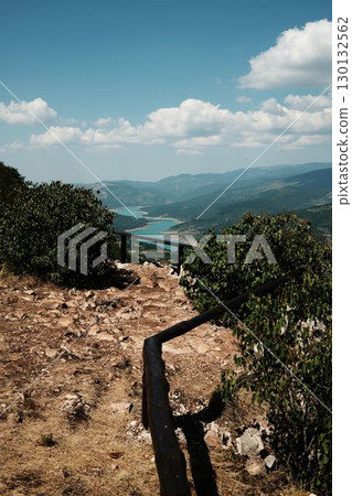Viewpoint with wooden fence overlooking turquoise river and mountains in Stara Planina, Serbia. View of Zavoj Lake in summer time season Viewpoint with wooden fence overlooking turquoise river and mountains in Stara Planina, Serbia. View of Zavoj Lake in summer time season 130132562
