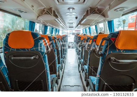 wide view clean and organized bus interior with empty seats and bright blue curtains. closeup. 130132633