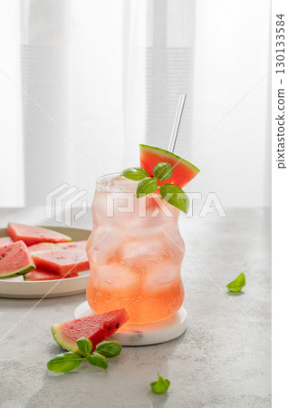 Watermelon mojito cocktail with ice and mint in a glass on a light table near window Watermelon mojito cocktail with ice and mint in a glass on a light table near window 130133584