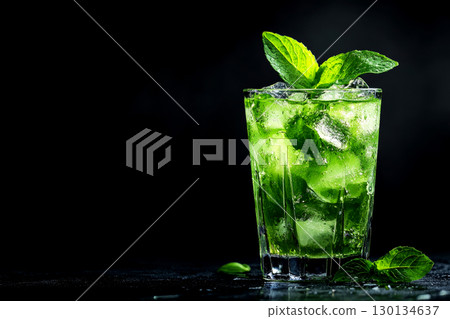 Vibrant cocktail made with fresh ingredients, ice, and mint leaves presented elegantly in a glass on a black backdrop Vibrant cocktail made with fresh ingredients, ice, and mint leaves presented elegantly in a glass on a black backdrop 130134637