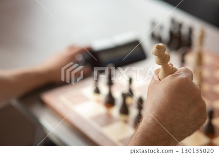 Close up of hands of middle aged caucasian man playing chess. Close up of hands of middle aged caucasian man playing chess. 130135020
