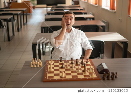 Middle aged Caucasian man playing chess.  130135023