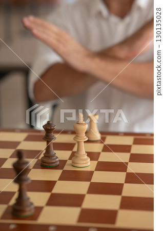 Close up of hands of middle aged caucasian man playing chess. Close up of hands of middle aged caucasian man playing chess. 130135028