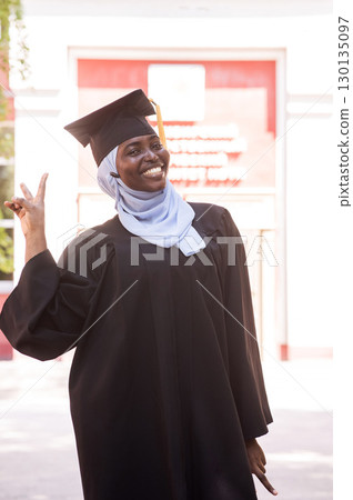 Portrait of happy african woman wearing hijab and graduation gown. Portrait of happy african woman wearing hijab and graduation gown. 130135097
