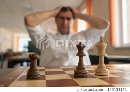 Middle aged Caucasian man playing chess. Middle aged Caucasian man playing chess. 130135151