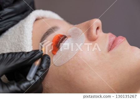 Caucasian woman undergoing eyelash lamination procedure.  130135267