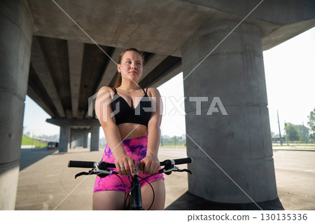 Caucasian woman in short shorts riding a bicycle. Caucasian woman in short shorts riding a bicycle. 130135336