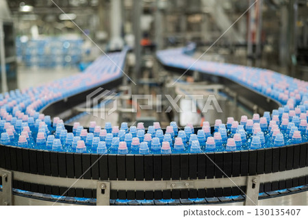 Bottled water on a conveyor belt at a factory.  130135407