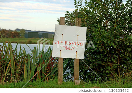 Old Fly Fishing Only Signboard at a Rural Trout Fishery in Summer 130135452