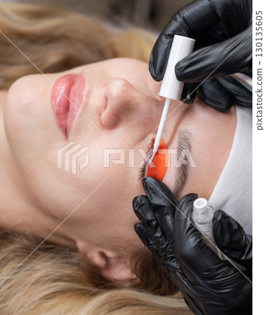 Caucasian woman undergoing eyelash lamination procedure. Caucasian woman undergoing eyelash lamination procedure. 130135605