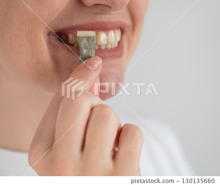 Woman Chewing Nicotine Snus Product.  130135660