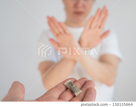 The woman refuses to take chewing tobacco.  130135664