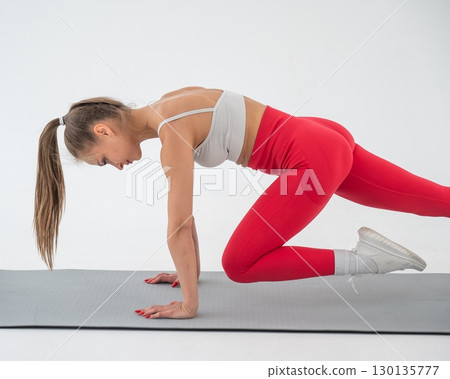 Young woman doing plank exercise on white background. 130135777