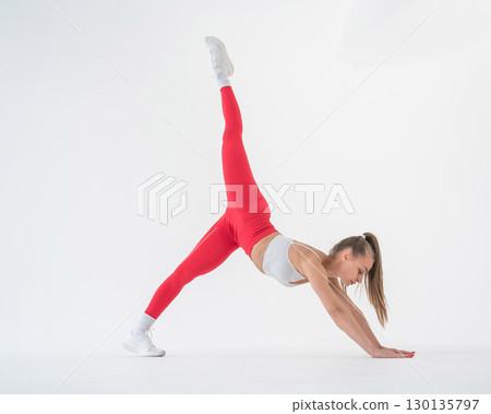 Caucasian woman doing sports exercises on white background.  130135797
