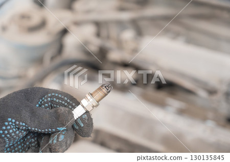 Caucasian man changing spark plugs in car.  130135845