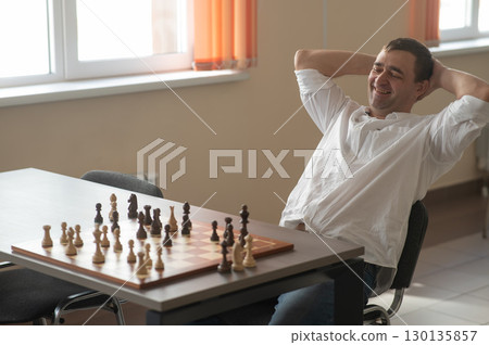Caucasian man thinking about a chess move. Caucasian man thinking about a chess move. 130135857