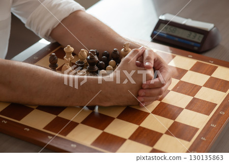 Close up of hands of middle aged caucasian man playing chess.  130135863