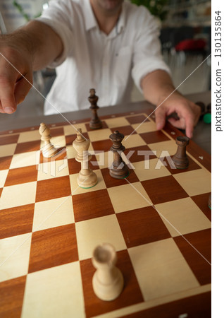 Close up of hands of middle aged caucasian man playing chess. Close up of hands of middle aged caucasian man playing chess. 130135864