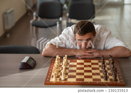 Middle aged Caucasian man playing chess. Middle aged Caucasian man playing chess. 130135913