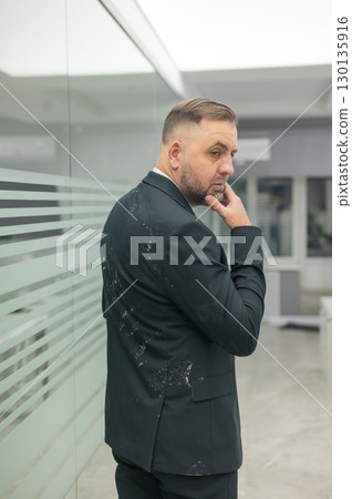 Caucasian man in dirty jacket in office.  130135916