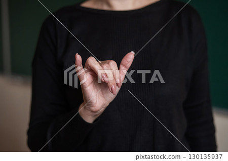 Woman showing the word university in Russian sign language.  130135937