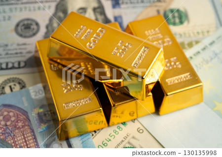 Gold bars with US dollar and Euro banknote money, finance trading investment business currency. 130135998