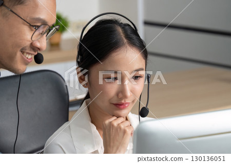 Call Center. Collaborative moment between agents in a busy office. 130136051