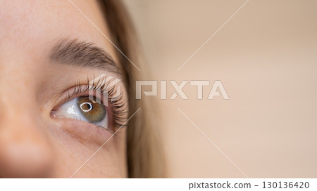Close-up of a woman's eye after eyelash lamination procedure. Close-up of a woman's eye after eyelash lamination procedure. 130136420