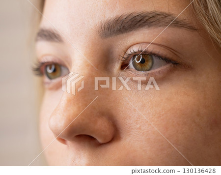 Close-up portrait of a woman after eyelash lamination procedure.  130136428