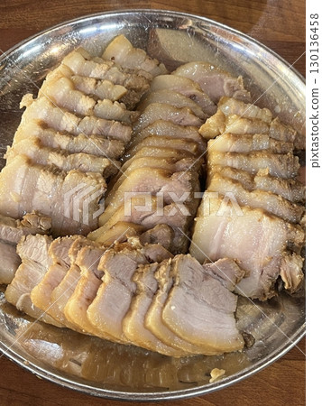 Suyuk, a traditional Korean dish of boiled pork slices, tender and juicy, often served with salted shrimp sauce, garlic, and ssamjang. Perfect for wrapping in lettuce for a flavorful, balanced bite. 130136458