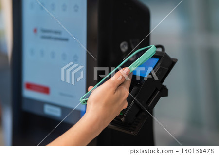Woman paying with credit card at self-checkout. Woman paying with credit card at self-checkout. 130136478